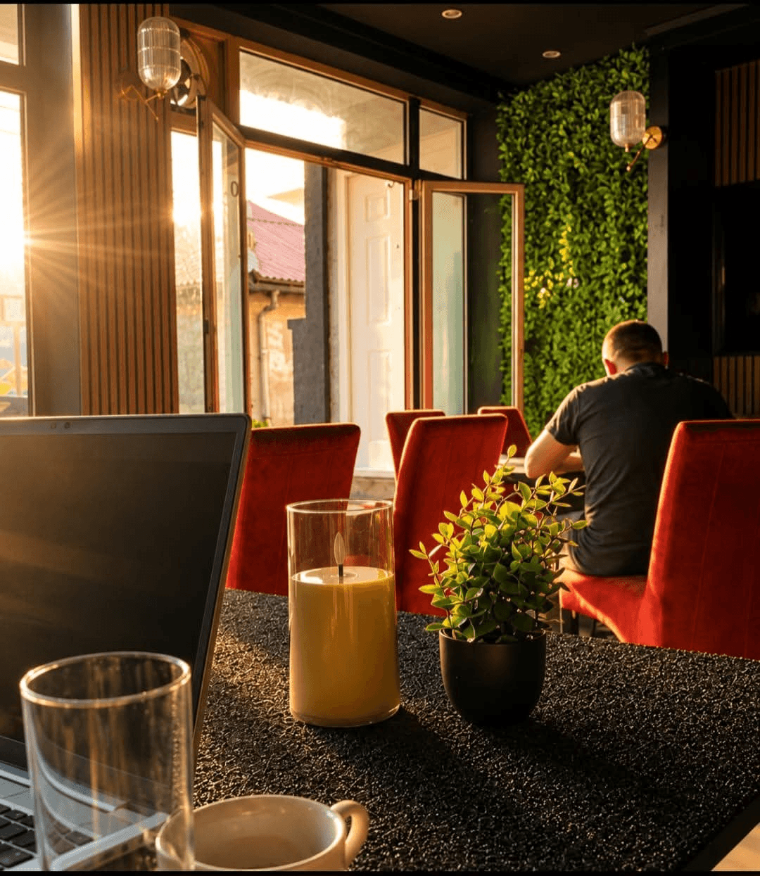 Golden hour light through windows, red velvet chairs
